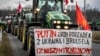 A banner on a tractor reads "Putin, sort out Ukraine, Brussels, and our government" as part of an ongoing protest by Polish farmers at the Ukraine border on February 20.