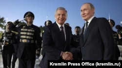 Uzbek President Shavkat Mirziyoev (left) and Russian leader Vladimir Putin at Tashkent airport on May 26.