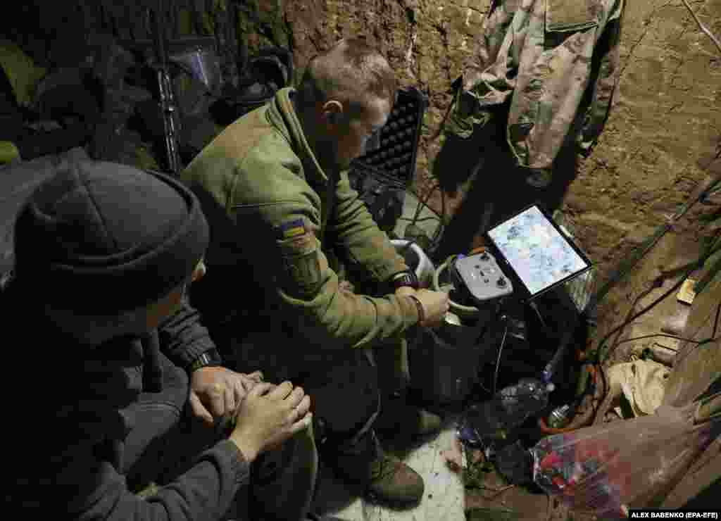 A Ukrainian operator watches a drone's progress on a small monitor at an undisclosed location on June 28. As inexpensive drones become more advanced, they are increasingly being integrated into the overall military structure on both sides. 