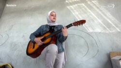 فلسطینۍ نجلۍ د غزې کوڅو کې د سولې سندرې وايي
