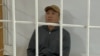 Askat Jetigen sits in a defendants' cage in a courtroom on May 23.