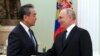 Russian President Vladimir Putin (right) greets Chinese foreign policy chief Wang Yi at the Kremlin in Moscow on February 22. The United States and NATO have accused China of considering supplying arms to Russia.