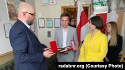 A BNR representative awards the medals to the relatives of the Losiks and Palchys.