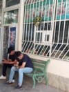 Мужчины со смартфонами на скамейке в Ашхабаде, 2024 год