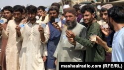 په کراچۍ کې افغان کډوال د استوګنې اسناد خبریالانو ته ښیې ـ پخوانی انځور.