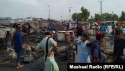 ځايي خلک او دوکانداران د امن مارکېټ تر سوځېدو وروسته د پېښې په ځای کې ولاړ دي - د اګست لومړۍ نېټې انځور.