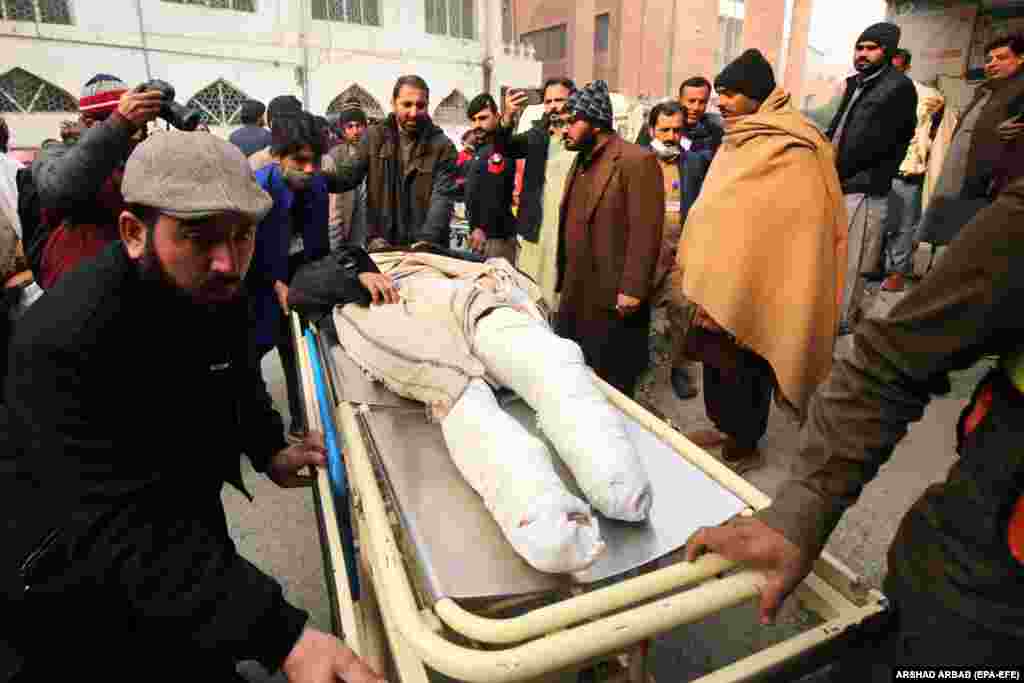 An injured man is transported to a hospital in Bajaur. Regional police spokesman Muhammad Asrar told RFE/RL&#39;s Radio Mashaal that the team of police personnel were on their way to guard polio workers performing immunizations in the area when their vehicle was hit by a roadside bomb.