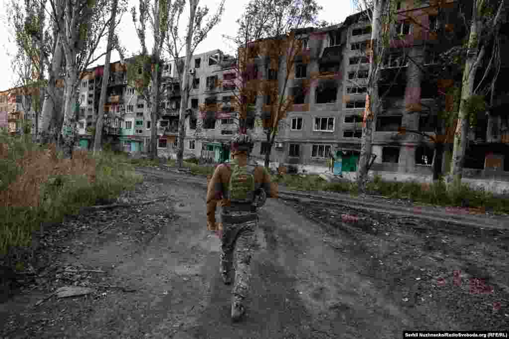 A soldier walks past ruined buildings in Vuhledar. The town was once home to around 14,000 people. Now, just a few hundred civilians -- and the Ukrainian military -- remain.