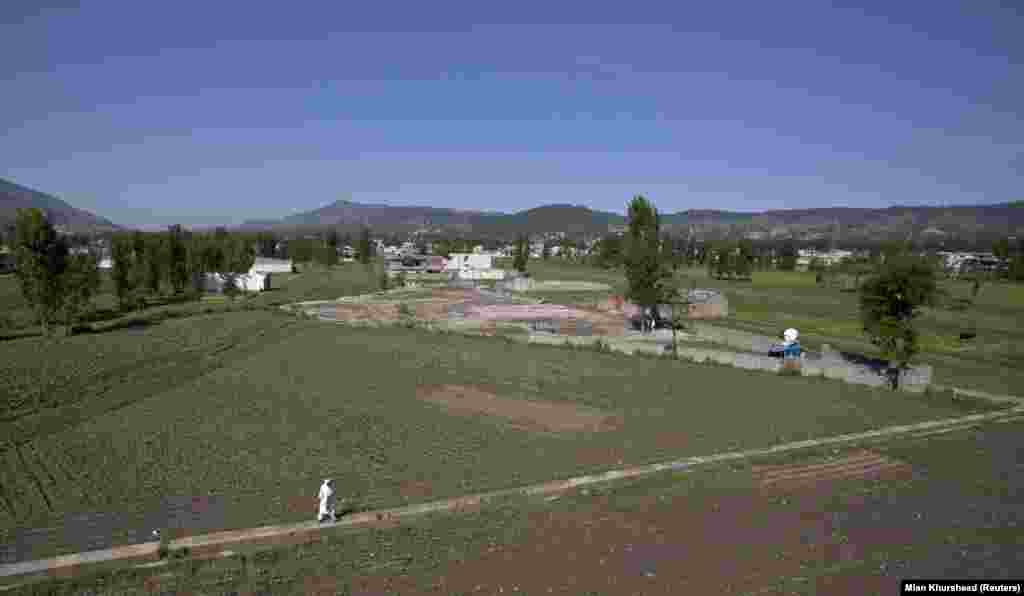 A man walks in 2012 near the the place where bin Laden&rsquo;s compound used to stand. &nbsp; Satellite images from 2021 show dozens of new houses have been built in the neighborhood since 2011, but the former site of the compound remains empty and has been used by locals to play cricket.