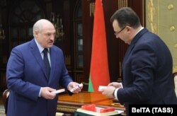 Belarusian Health Minister Dzmitry Pinevich (right) presents a batch of Russian Sputnik V vaccine to Alyaksandr Lukashenka in Minsk earlier this year.