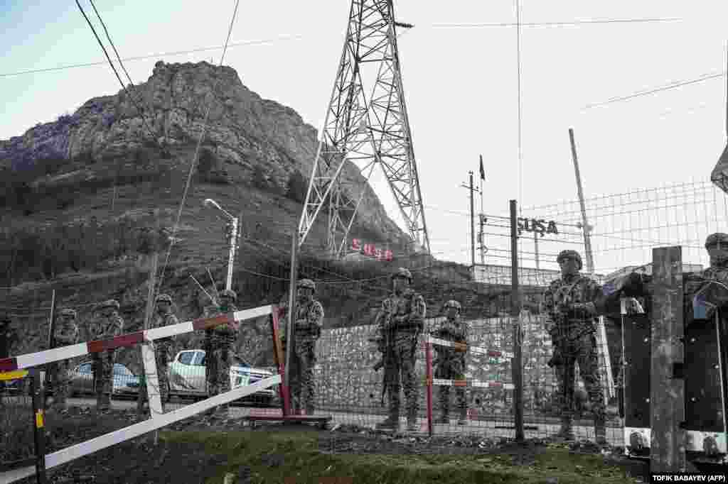 Azerbaijani servicemen guard a checkpoint at the Lachin Corridor. Armenia contends the protests are orchestrated by Azerbaijan, and the United States has called on Baku to lift the blockade. 