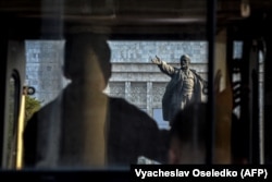 Lenin szobrát nézi Biskekben egy tüntető 2021-ben.