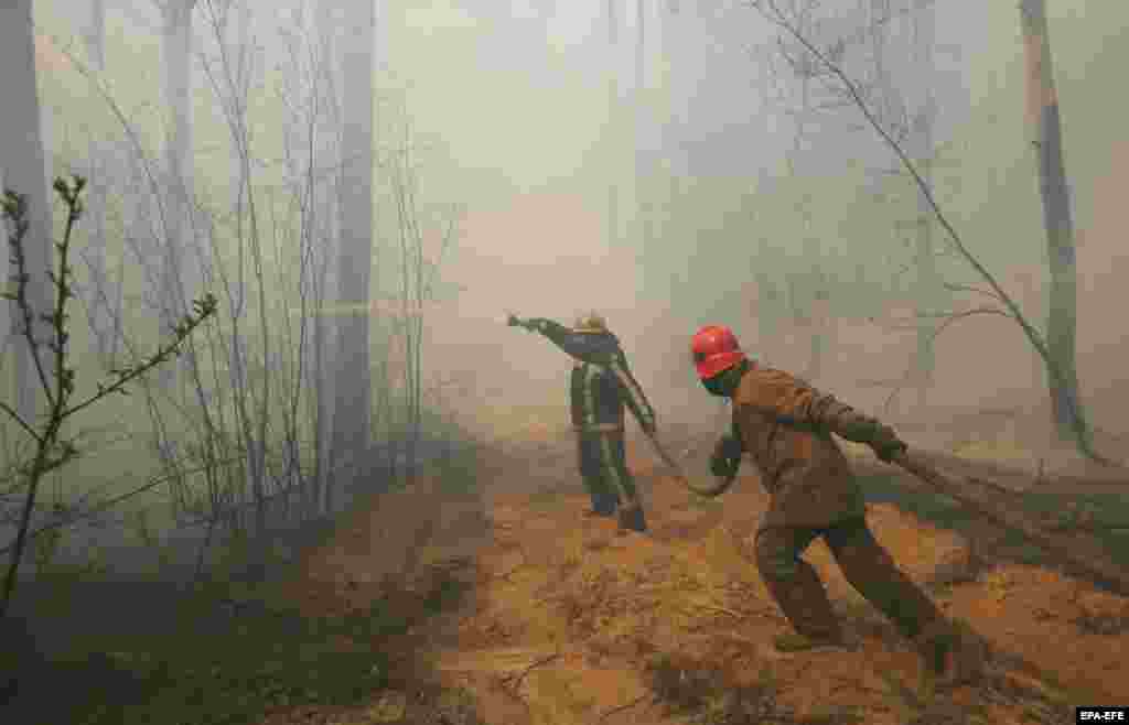 Ukrainian firefighters battle flames near the village of Rahivka on 10 April.The fires began on April 3 in the western part of the uninhabited exclusion zone before spreading to nearby forests.