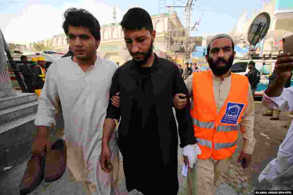An injured man is led away.
