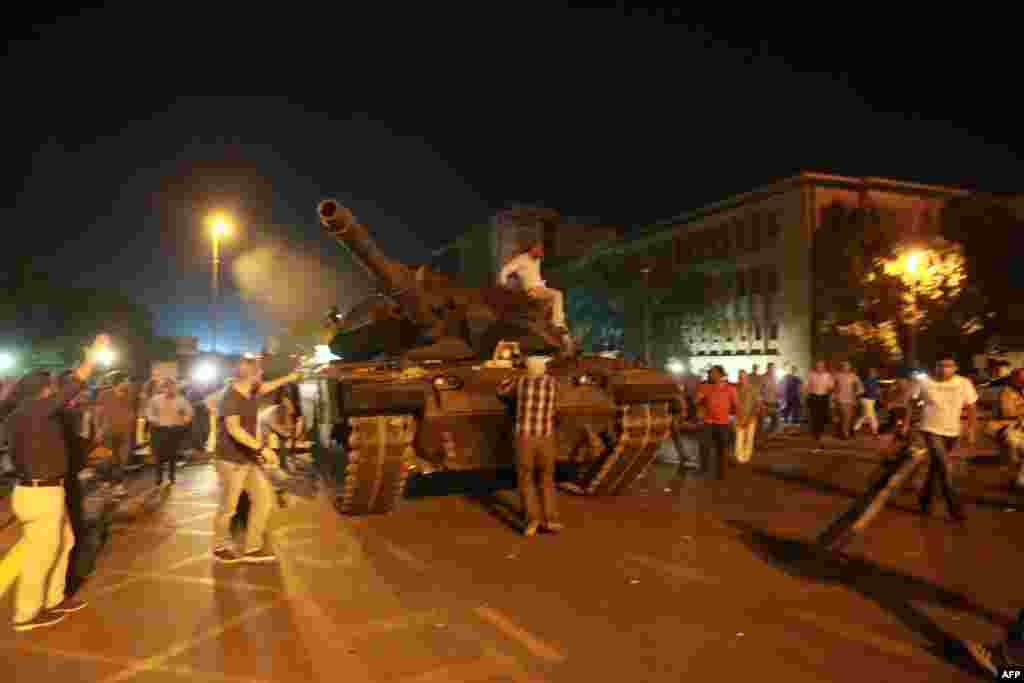 People try to take over a tank in Ankara. In an address to Turkish television, Erdogan had urged people to take to the streets. 