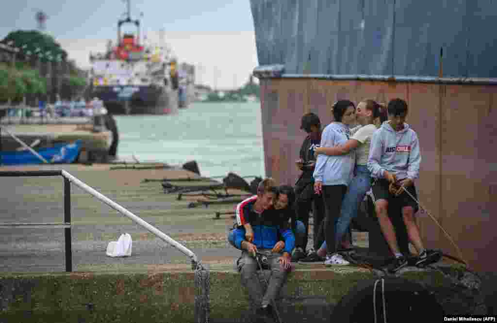 Young locals relax at a port on the Sulina Canal. International observers warn that a food crisis is looming as a result of Moscow's invasion of Ukraine, especially in some African countries that rely mostly on shipments from Russia and Ukraine for their grain supply. The UN has warned of a "hurricane of hunger" if grain transport out of Europe cannot be sped up. 