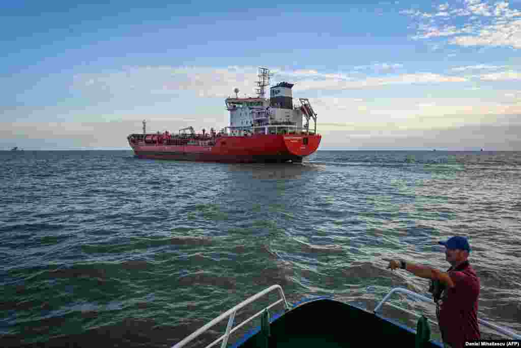 A Romanian pilot boat crewman is seen in front of a ship preparing to enter the Sulina Canal. A director of a Romanian port operations company told Al-Jazeera that "Considering the large grain volumes that are in need of export from Ukraine, I believe this has to be a conjugated effort of all the European operators that have the capacity to participate." He added, "There is no place for ego here."