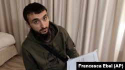 Tumso Abdurakhmanov holds a letter from Interpol during an interview with AP somewhere in Poland in November 2018.