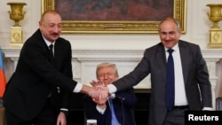 Әзербайжан және Армения басшылары Ақ үйде қол алысып тұр.