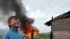 Romany boys watch shanties burn in Sarajevo suburb in June 2009