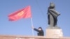 Kirgiz zászlót lenget egy férfi a szovjet vezető, Vlagyimir Lenin szobránál Os belvárosában. A helyi hatóságok júniusban bontatták le az emlékművet. 