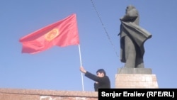 Kirgiz zászlót lenget egy férfi a szovjet vezető, Vlagyimir Lenin szobránál Os belvárosában. A helyi hatóságok júniusban bontatták le az emlékművet. 