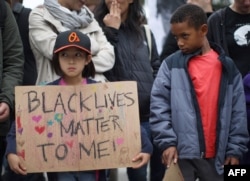 Protesters at a rally, expressing anger over the decision not to try the policeman whose chokehold killed Eric Garner in New York, near police headquarters in Los Angeles, California.