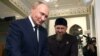Kadyrov (C) shows Koran to Russia's President Vladimir Putin (L) during his visit to Chechnya in Grozny