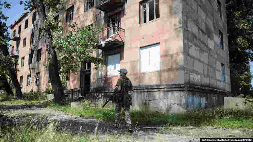 Військовий Збройних сил України біля «Дому Павлова» – саме так називають два будинки, які розташовані за КПВВ «Золоте». Центральна сторона одного з будинків виглядає у бік позицій російських гібридних сил