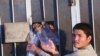 An Afghan man takes empty water bottles from Afghan men in Iranian detention in the southeastern Iranian city of Zahedan (file photo). Afghan officials say more than 5,600 Afghan nationals are in Iranian prisons for alleged drug crimes.