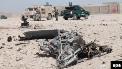 Afghan security forces inspect the scene of a suicide bombing at a police station in Lashkar Gah, the provincial capital of restive Helmand Province, on October 10.