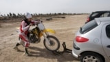 Female Iranian motorcross champion Noura Naraghi, 23, attaches her bike to her car at the conclusion of a training session in Nassim Shahr, southwest of the capital Tehran, Iran,