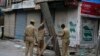 Indian police officers erect a tin and barbed wire barricade in Srinagar, the summer capital of Kashmir on July 11.