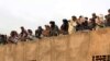 Afghan Taliban fighters listen to Mullah Mohammad Rasool Akhund (unseen), the newly appointed leader of a breakaway faction of the Taliban, at Bakwah in the western province of Farah in November 3.