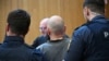 Предполагаемият ръководител на групата Дитер С. е ескортиран до съдебната зала.