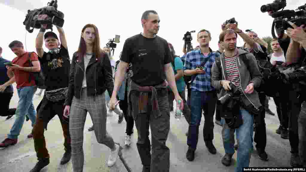 Ukrainian director Oleh Sentsov walks past journalists with his daughter, Alina.