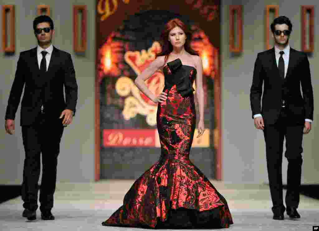 Chapman struts down a Turkish catwalk flanked by two men posing as secret service agents at a fashion show in Antalya on&nbsp;June 8, 2012.