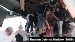 Citizens evacuated from Afghanistan arrive at the airport in Hissar, Tajikistan, on August 26.