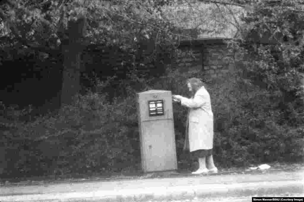 Starija žena ubacuje pismo u poštanski sandučić, zima je u vrijeme komunističke Istočne Njemačke (DDR-a odnosno Njemačka Demokratska Republika). 