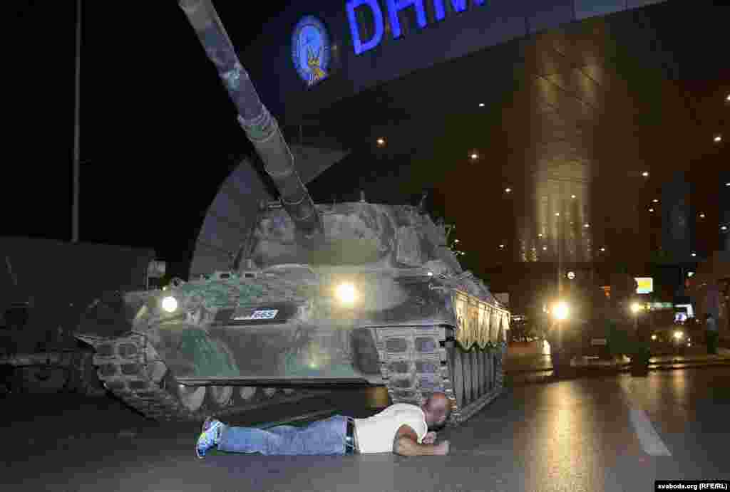 A man lies in front of a Turkish Army tank at Ataturk airport in Istanbul. As flights were suspended, Turkish Airlines took to Twitter to condemn the attempted coup, saying, "Citizens who believe in democracy and freedom to stand up against this attack on our Parliament and our public representatives."