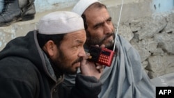Afghan men listen to a radio broadcast by the Voice of the Caliphate station run by Islamic State in December 2015.