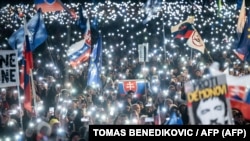 Хора държат светлини, словашки знамена и знамена на ЕС и НАТО по време на антиправителствен протест на площад „Свобода“ под мотото „Словакия е Европа“, Братислава, 7 февруари 2025 г. 