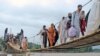 Flood victims cross a temporary bridge as they flee flooded areas of Chakdara, a region in Khyber Pakhtunkhwa Province in early August.