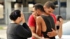 Friends and family members embrace outside Orlando Police Headquarters after a mass shooting at the Pulse night club.