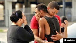 Friends and family members embrace outside Orlando Police Headquarters after a mass shooting at the Pulse night club.