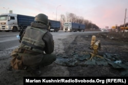 A Ukrainian soldier crouches next to an anti-tank missile at the scene of a battle on the outskirts of Kharkiv.