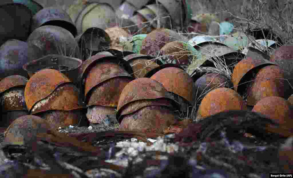 Rusted army helmets litter the ground with other damaged ammunition on the outskirts of Stepanakert on November 23.
