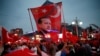 A supporter holds a flag depicting Turkish President Tayyip Erdogan during a pro-government demonstration in Ankara, Turkey on July 20.