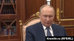 Russian President Vladimir Putin in front of a bookcase in his office in the Kremlin's Senate Palace in Moscow 