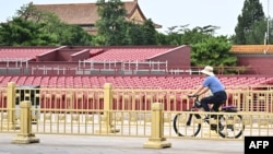 Un bărbat merge pe bicicletă prin fața standurilor pregătite în Piața Tiananmen din Beijing, pregătită pentru parada militară din 3 septembrie, care marchează 80 de ani de la victoria Chinei asupra Japoniei în Al Doilea Război Mondial.